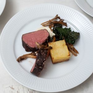 Helstegt oksemørbrad serveret med ristede østershatte, selleripure og palmekål. Hertil pommes Anna og kraftig rødvinssauce